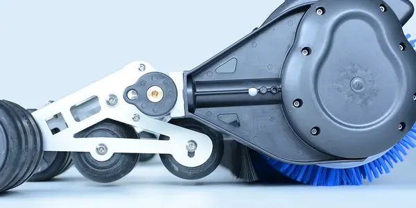 Detailaufnahme einer Reinigungsmaschine mit blauer Bürste und robusten schwarzen Rädern.